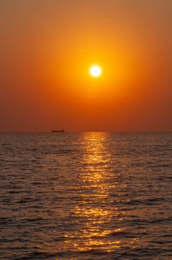 Gün batımı denizin üzerinde ve geminin üzerinde