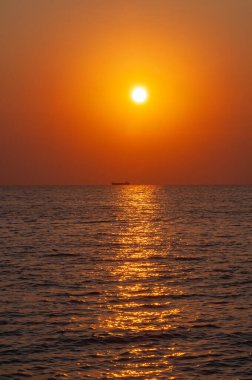 Gün batımı denizin üzerinde ve geminin üzerinde