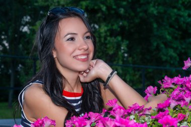 Yanında güzel çiçekli petunyaları olan genç bir kadın.