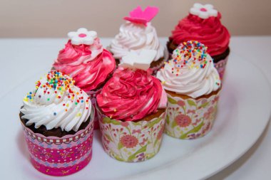 Vanilyalı ve çikolatalı kekler. Pembe ve beyaz kremalı. 