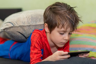 Cep telefonu tutan sevimli çocuk. Evde yalnızlık çekmekten sıkıldım..