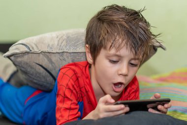 Cep telefonu tutan sevimli çocuk. Evde yalnızlık çekmekten sıkıldım..