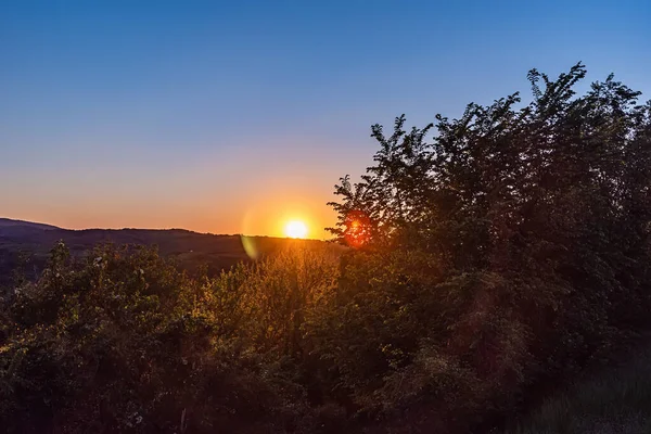 Sırbistan 'ın Voyvodina kentinde, Fruska Gora dağı yakınlarında gün batımı. Dağların üzerinden gün batımı