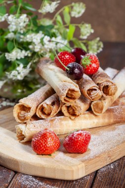 Kiraz, çilek ve ev yapımı keklerle süslenmiş kremalı gofret.