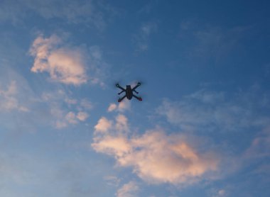 Aşağıdan gün doğarken gökyüzünde bir dron