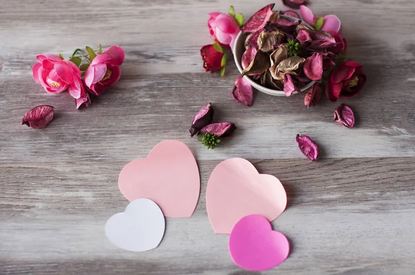 Droge lucht bloemblaadjes roze rozen liggen op de tafel in een witte beker, in de buurt van — Stockfoto