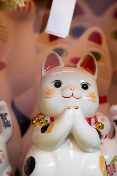 A group of ceramic Japanese lucky cats in the display cabinet (subtitle: Lucky Cat, Jin Yun Laifu)