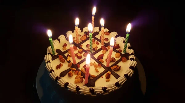 Fødselsdagskage med lyse lys af stearinlys isoleret på backgrou - Stock-foto