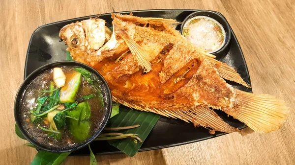 Pescado frito de río en plato negro — Foto de Stock