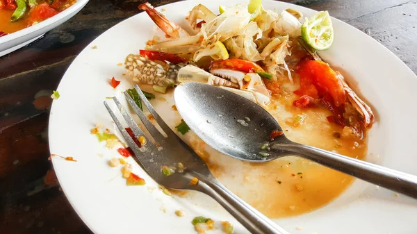 Empty dirty plate seafood paste on wooden table left after lunch — Stock Photo, Image