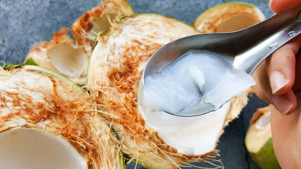 Use colher pegando cocos verdes jovens com nutriente, saúde — Fotografia de Stock