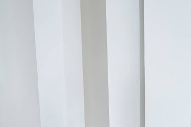 Beyaz bir duvara karşı dikey beyaz sütunlar