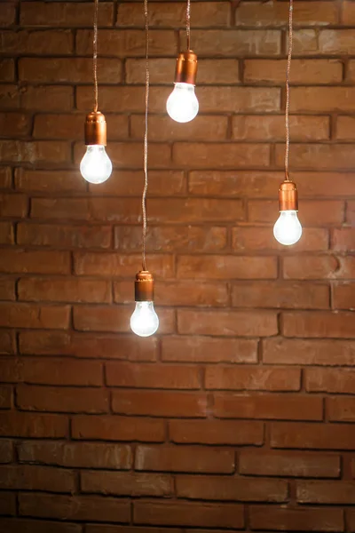 Lampen met draden op een bakstenen wandachtergrond — Stockfoto