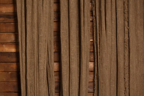 Brown burlap on a brown wooden wall background — 스톡 사진