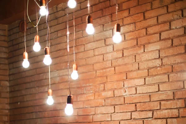 Lampade con fili su uno sfondo muro di mattoni — Foto Stock