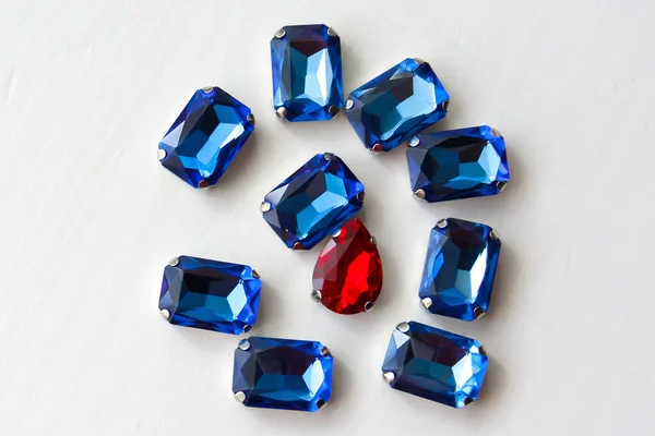 Кристаллы из синих и красных камней на белом деревянном фоне — стоковое фото