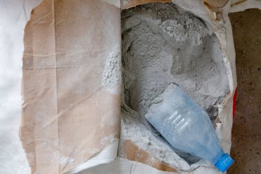 Karton bir çantada kuru toz gri bina karışımı, beton ya da alçı.
