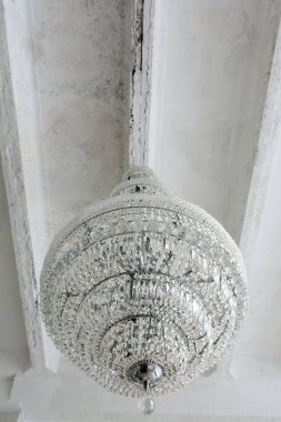 Beton beyaz ya da gri tavanda kocaman kristal bir avize.