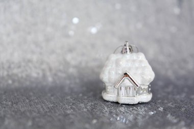 Noel, Yeni Yıl geçmişi ve dokusu. Kardaki Noel ağacı oyuncak evi, parlak gümüş pullarla işlenmiş kumaş ya da kumaşın üzerinde duruyor.