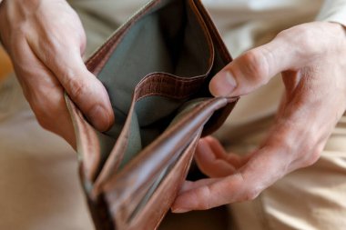 Hafif monofonik arka plandaki bir adamın elinde boş bir cüzdanın yan görüntüsü. Ekonomi ve finans sektöründe iflas ve iflas. İnsanların parası yok..