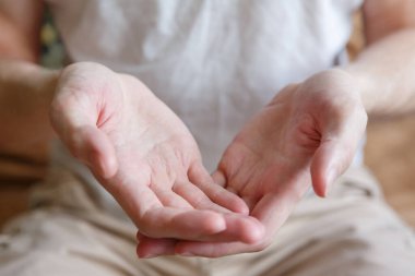 Erkek eli bir şey tutar ya da verir. El hareketi. Parmaklar ve avuçlar