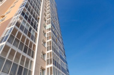 Mavi gökyüzüne karşı yeni bir binanın cephesi, alt manzara. İnşaat endüstrisi ve sanayi