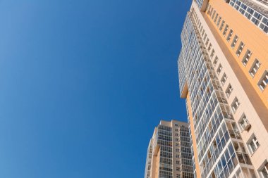 Mavi gökyüzüne karşı yeni bir binanın cephesi, alt manzara. İnşaat endüstrisi ve sanayi