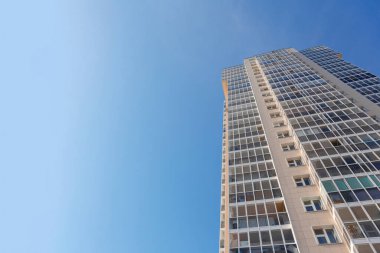 Mavi gökyüzüne karşı yeni bir binanın cephesi, alt manzara. İnşaat endüstrisi