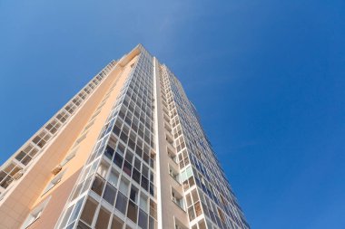 Mavi gökyüzüne karşı yeni bir binanın cephesi, alt manzara. İnşaat endüstrisi