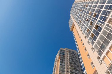 Mavi gökyüzüne karşı yeni bir binanın cephesi, alt manzara. İnşaat endüstrisi