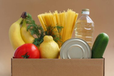 Yiyecek stoğuyla dolu bir kutu. İhtiyacı olanlar için ürün bağışı. Meyve, sebze, konserve ve makarna.