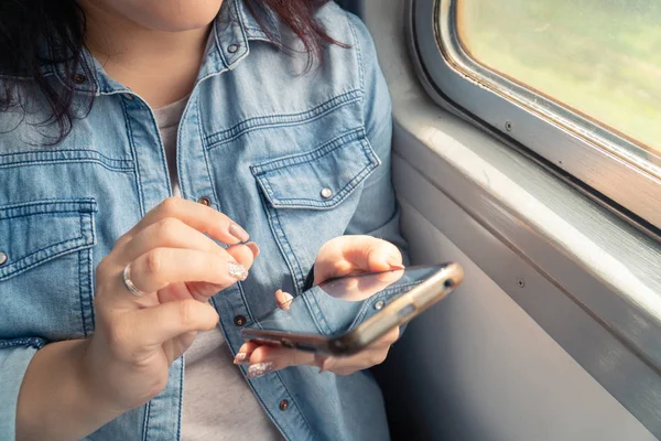 Joven hermosa chica caucásica utiliza teléfono inteligente en el transporte público durante el viaje — Foto de Stock