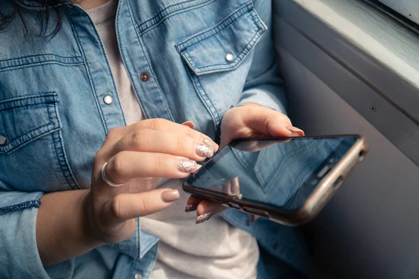 Joven hermosa chica caucásica utiliza un teléfono inteligente en el transporte público durante el viaje — Foto de Stock