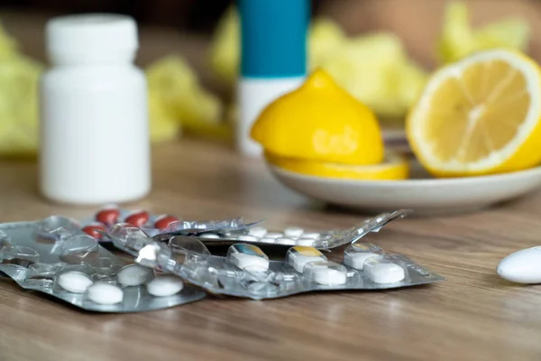 Cytryna w plasterkach z tabletkami na zimno na stole — Zdjęcie stockowe