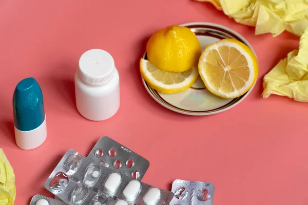 Conceito de frio: limão fatiado com pílulas frias e spray nasal em fundo rosa — Fotografia de Stock