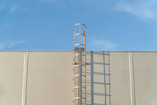 Échelle d'évacuation en métal blanc sur le toit d'un bâtiment à clins — Photo