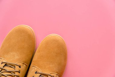 Pembe arka planda, kopyalama alanı olan sarı çizmeler.