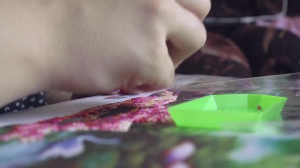 Primer plano de una chica recogiendo una pintura de diamante usando un lápiz — Vídeos de Stock