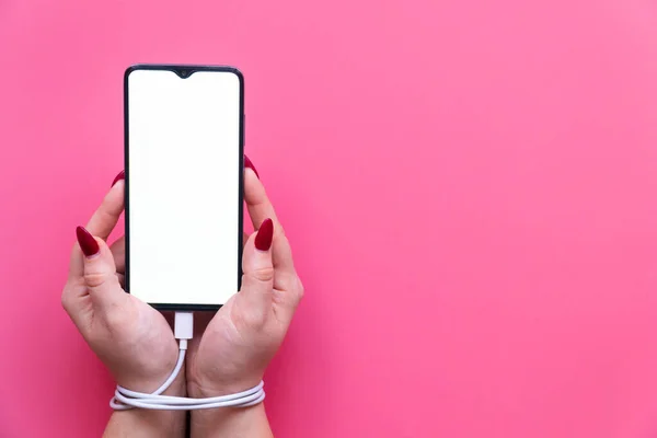 Pembe arka planda modern bir akıllı telefon olan kadın ellerini kapat. Sosyal ağ sitelerine, internete ve aygıtlara bağımlılık .