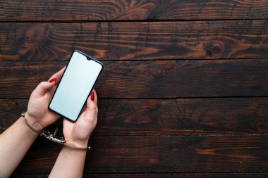 Elleri kelepçeli kadın elleri boş ekranlı akıllı telefonu mesaj ya da logo için tut. İnternet bağımlılığı, sosyal ağ ve aygıtlar kavramı.