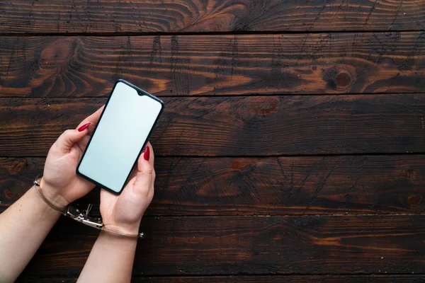 Elleri kelepçeli kadın elleri boş ekranlı akıllı telefonu mesaj ya da logo için tut. İnternet bağımlılığı, sosyal ağ ve aygıtlar kavramı.
