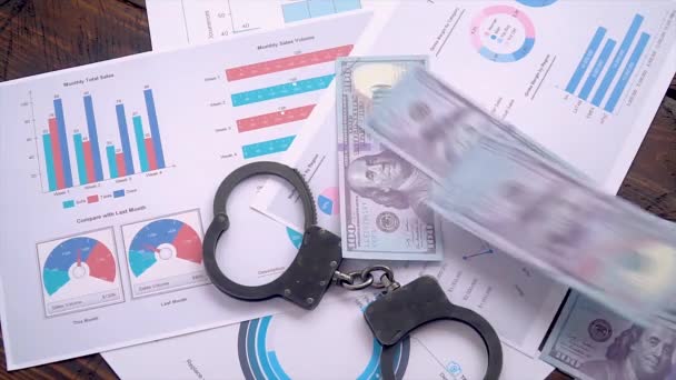 Доллары Разбросаны Столу Наручниками Графиками Продаж Концепция Коррупции Бизнесе — стоковое видео