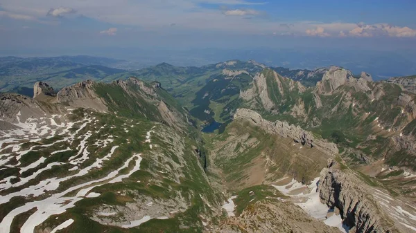 Hory a kopce v oblasti Alpstein počátkem léta. Jezero Seealpsee. — Stock fotografie