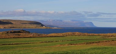 Yeşil çayır ve mavi Atlas Okyanusu. Kuzey İzlanda sahnede.