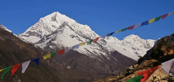 Prayer flags and snow capped Sunder Peak. — Stock Photo, Image