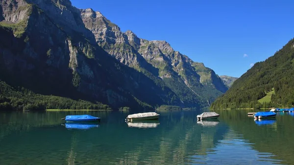 Dia de verão no lago Klontalersee, Suíça. Barcos de pesca. Gla... — Fotografia de Stock