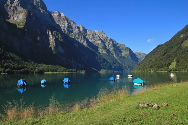 Klontalersee で緑の草原 釣り舟と山の範囲 Glarnisch スイスの夏のシーン — ストック写真