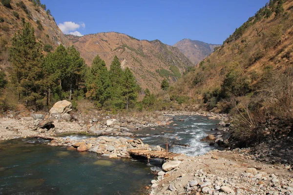 Eenvoudige houten brug en Langtang Khola, rivier in Nepal. — Stockfoto