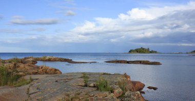 Vanern Gölü kıyısında kaya oluşumları ve küçük ada.