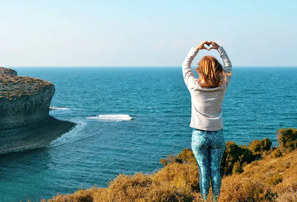 Ragazza Che Tiene Una Forma Cuore Sulla Riva Dell Oceano — Foto Stock